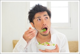 サラダを食べる男性